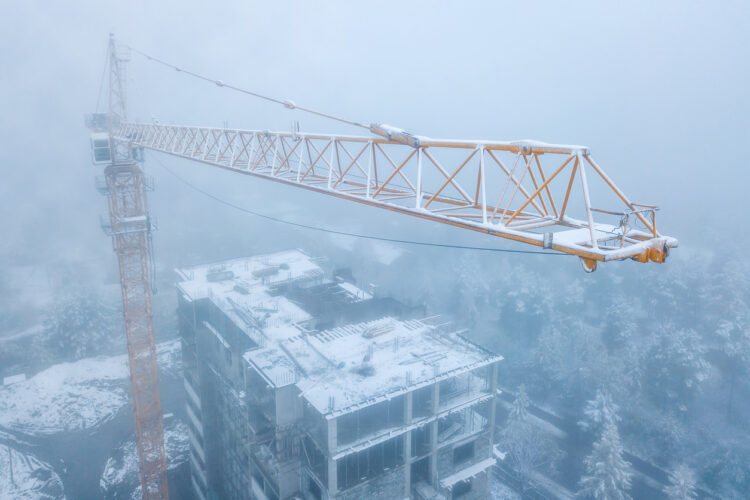 Tower Crane Operating On Snowy Commercial Construction Site