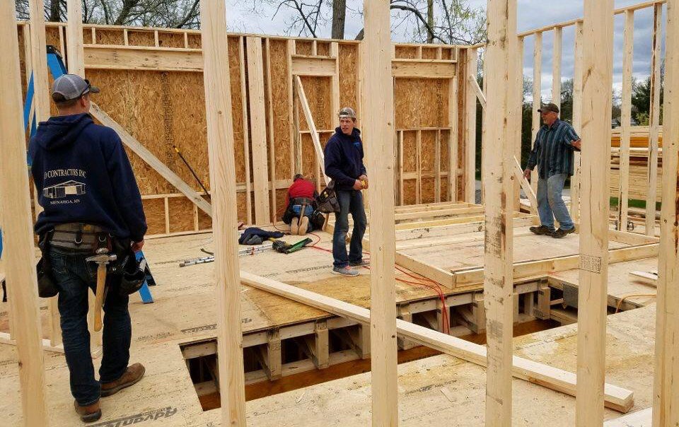 Commercial construction workers assembling wooden framing for a new building project.