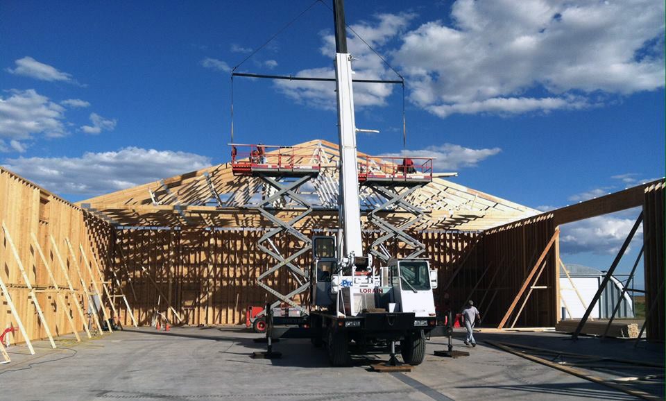 Hybrid steel building under construction with wood framing and crane support