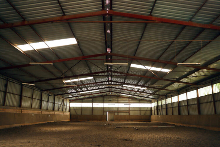 Spacious horse barn construction with metal roof and open interior